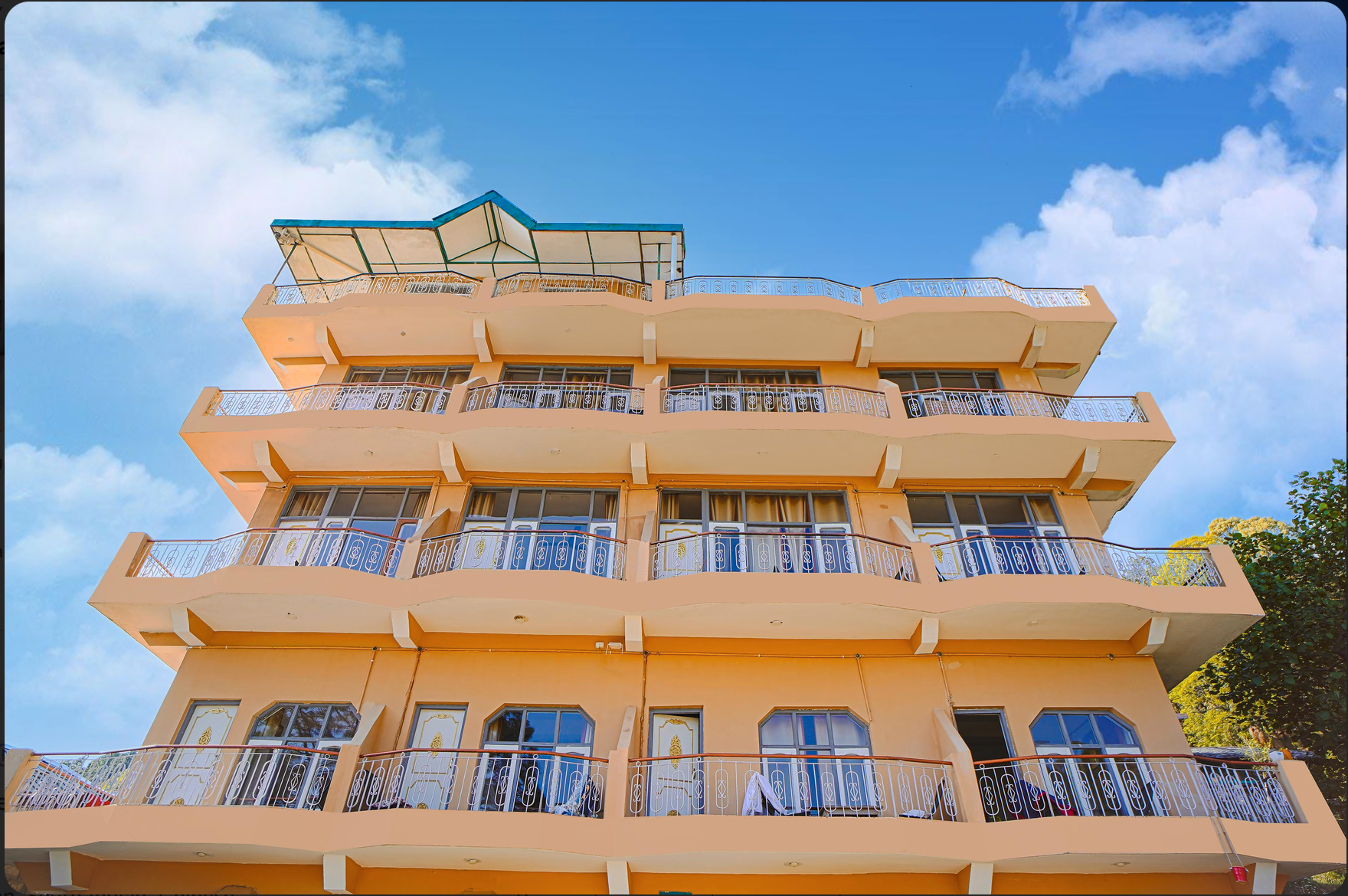 The Pine Resort building with five tiers of balconies under a blue sky