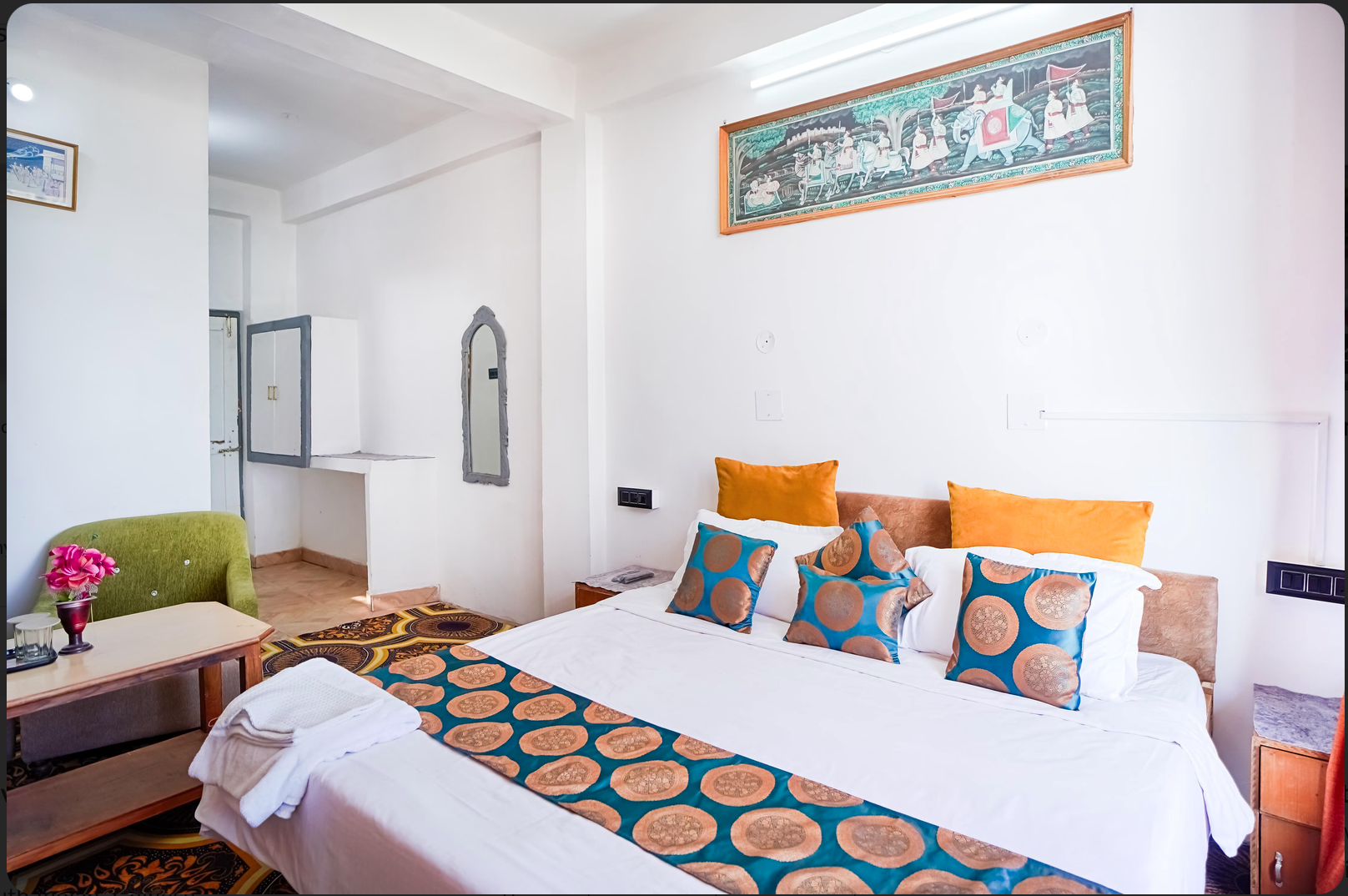 Super Deluxe room with king bed, private balcony, sitting area and Pahari art